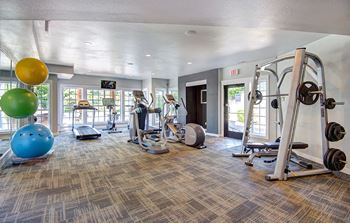 spacious gym with cardio machines and weights at the at the village apartments at Deer Creek Apartments, Puyallup, WA, 98373
